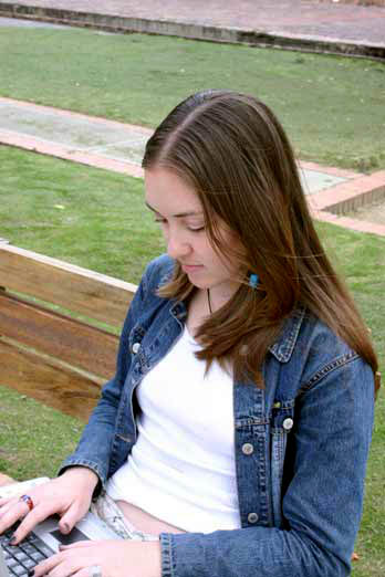 woman sitting on a bench with a laptop